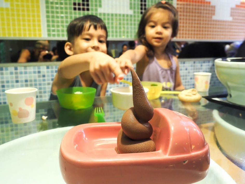 Two kids pointing at ice cream that looks like poo in Modern Toilet Restaurant, Ximending