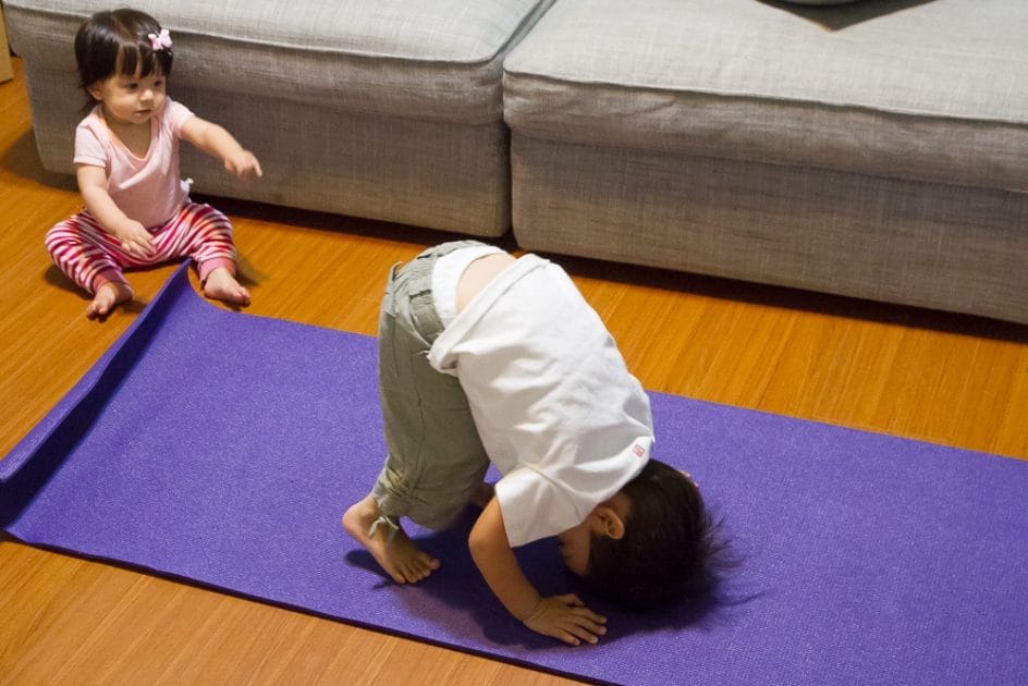 My toddler son showing off his yoga moves to my baby daughter