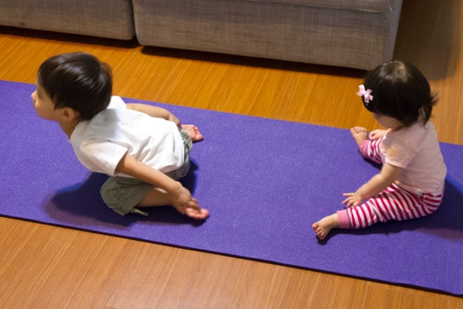 my toddler son showing off his yoga moves to my baby daughter