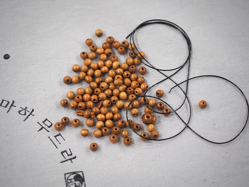 Making bracelets with 108 beads during the Beomeosa temple stay