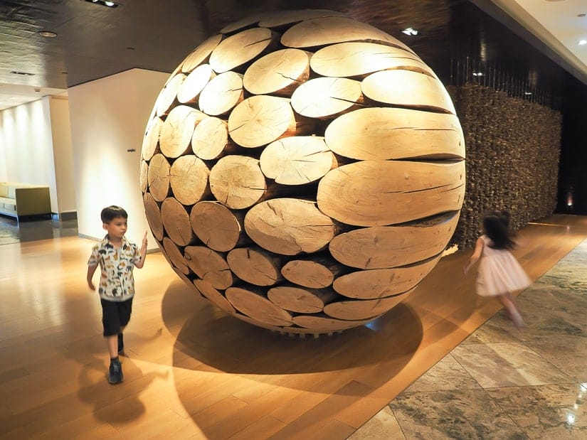 Our kids running around a large artwork in the lobby of Grand Hyatt Taipei