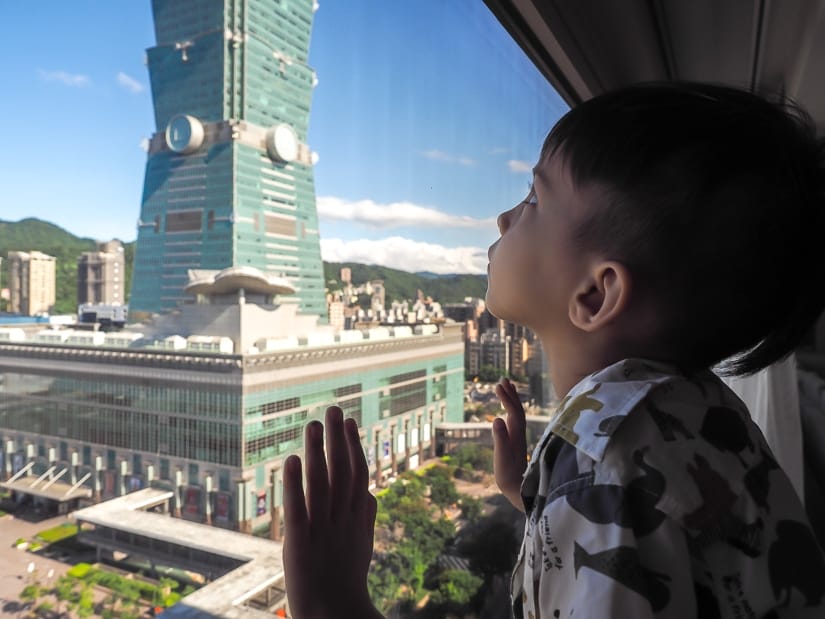 My son looking at Taipei 101 from the living room window of our Grand Executive Suite