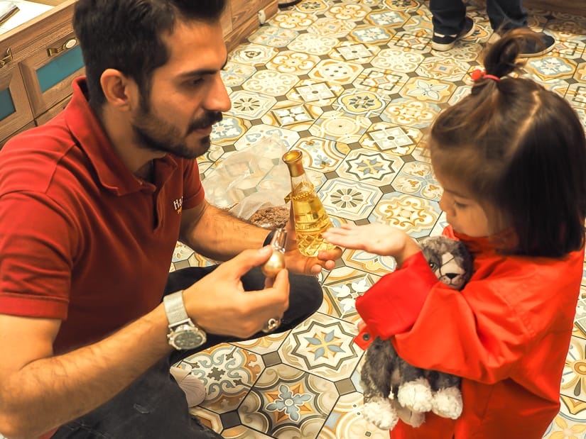 A spice market vendor putting some perfume on my daughter's wrist