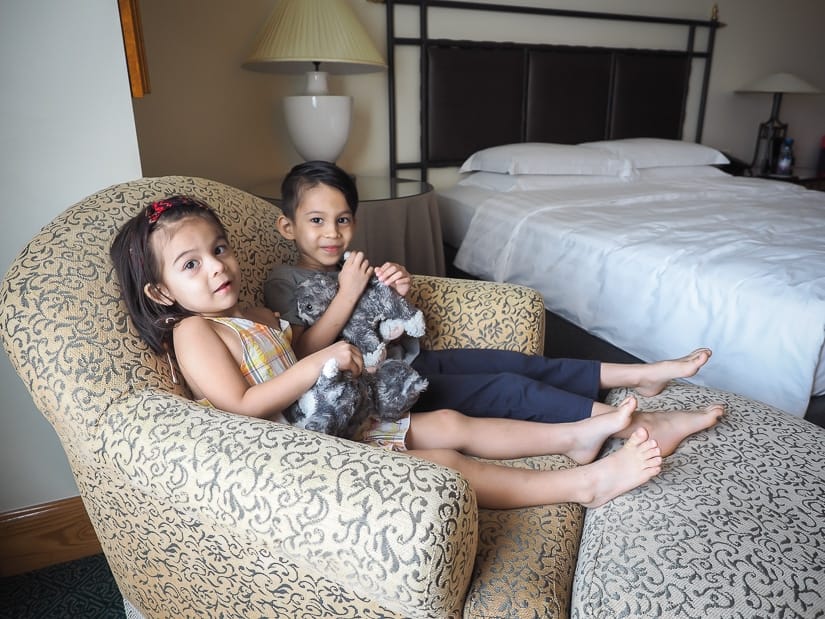 Our kids sitting in a love seat in our Grand Hyatt suite