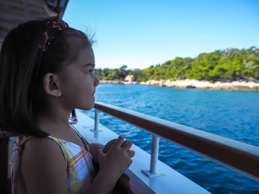 Child on ferry with shore of Lokrum Island in background