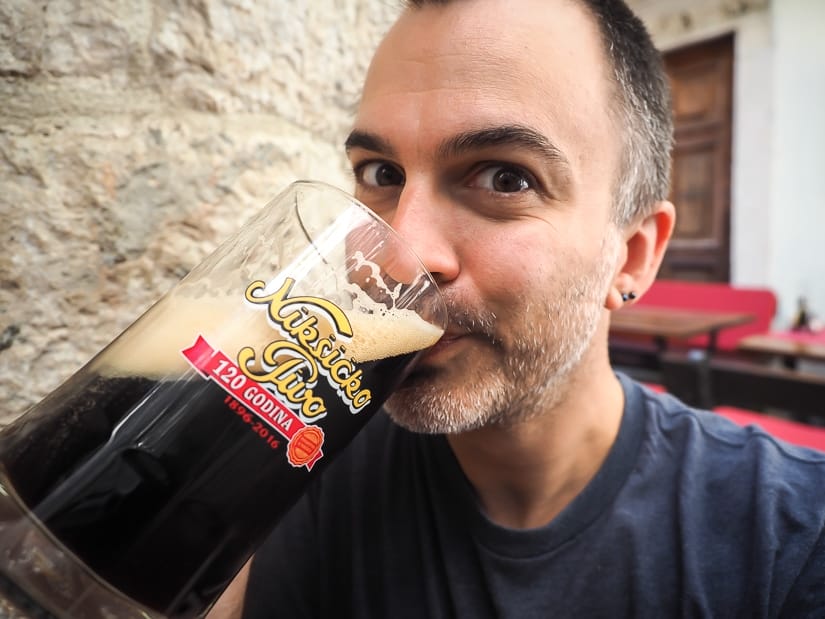 Me drinking a large glass of local Montenegro Niksicko beer at a restaurant in Kotor