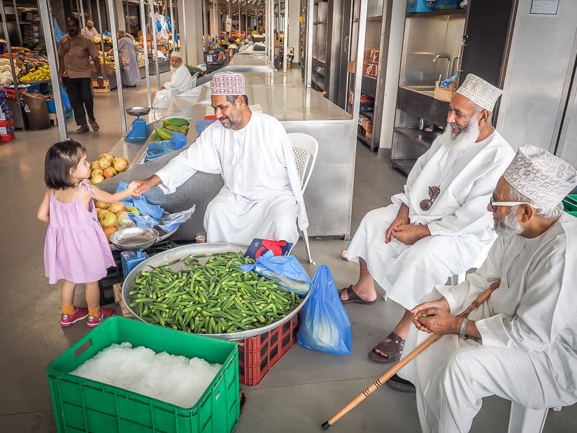 Our daughter interacting with local Omani people in a vegetable market