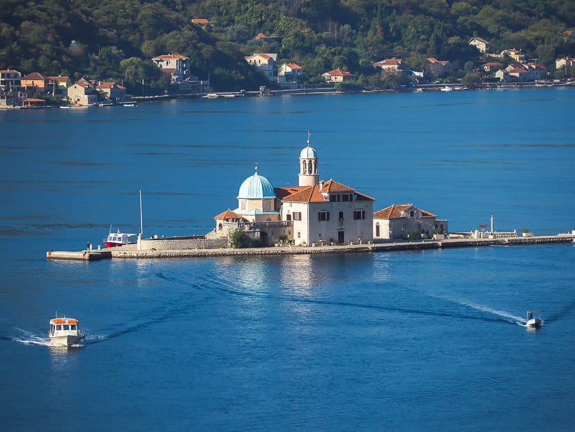 Two boats sailing away from Out Lady of the Rocks, the most famous of the places to visit in Perast