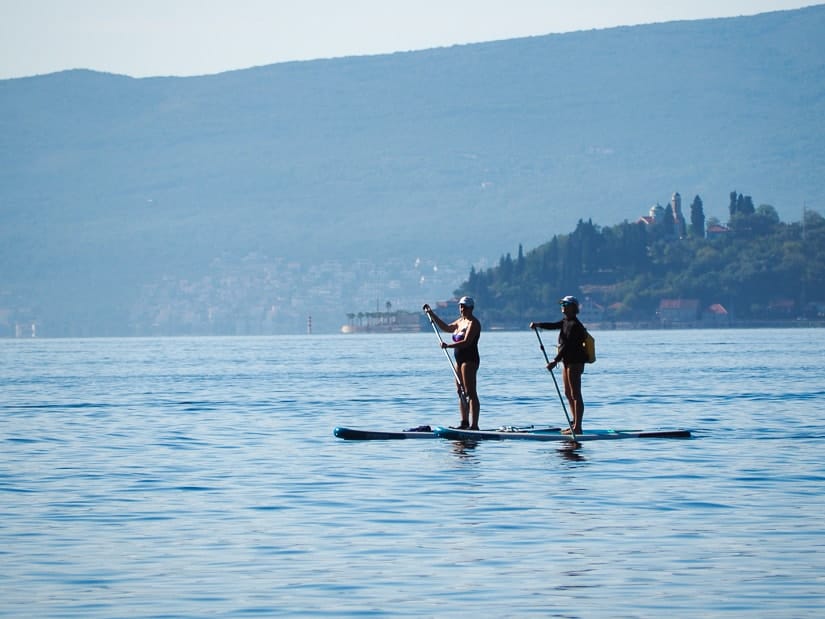 Two people stand-up paddle boarding on the Bay of Kotor