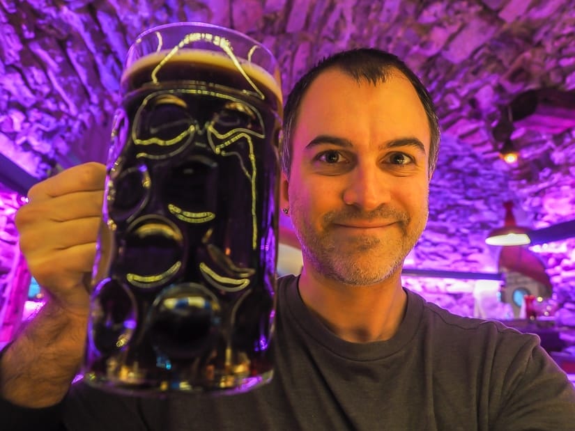 Me holding a large glass of dark beer at Braukeller restaurant in Seefeld