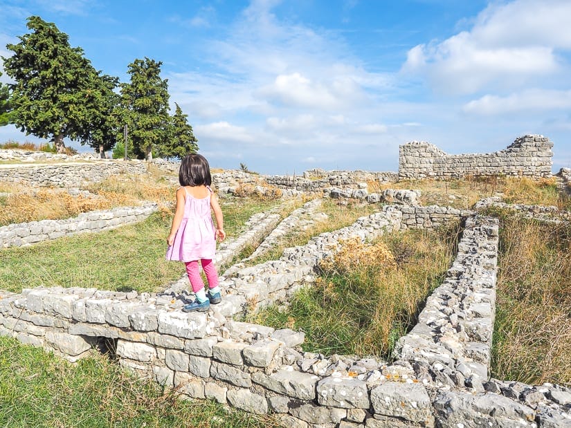 My daughter overlooking some ancient ruins, which we were able to visit by renting a car for our Croatia family trip