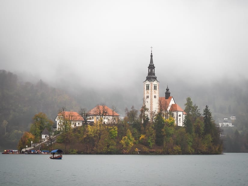 Lake Bled in October and November: Bled Island with lots of gray clouds over it