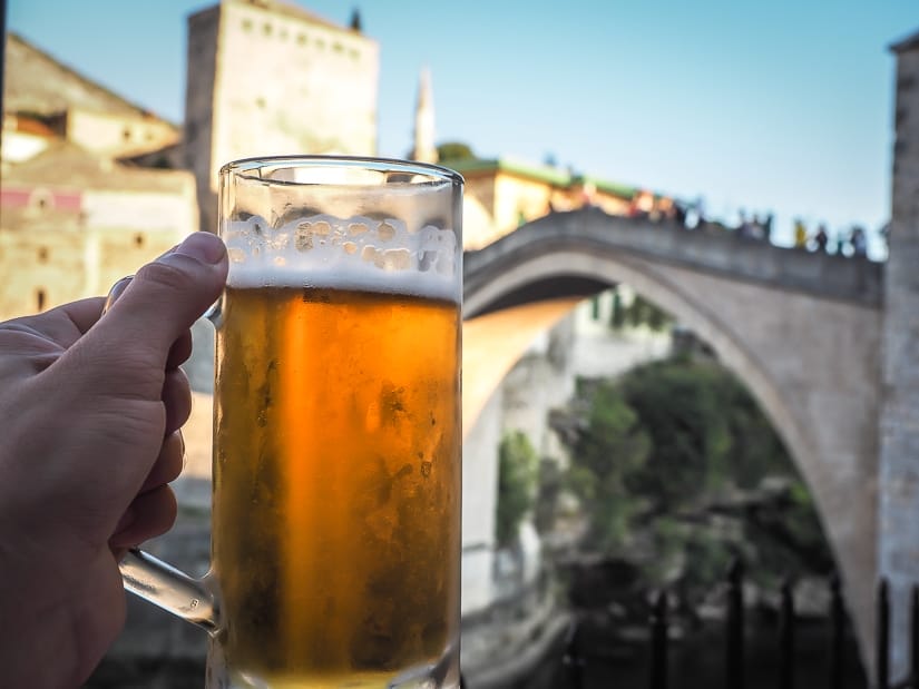 A large beer with Mostar Bridge in the background