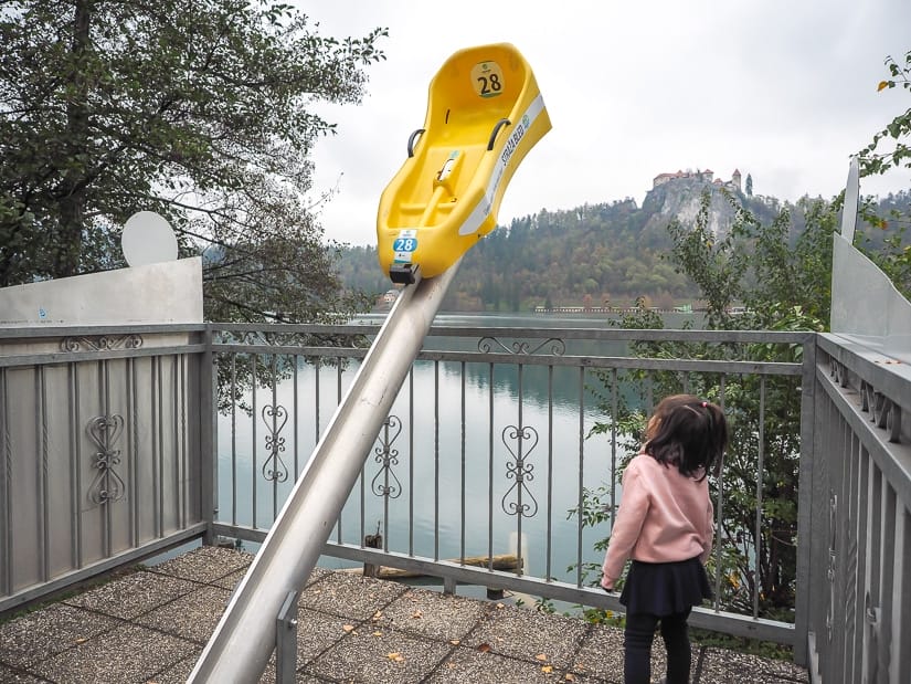 A toboggan statue beside Lake Bled, with one of the toboggans from Straza Hill when it is closed in November