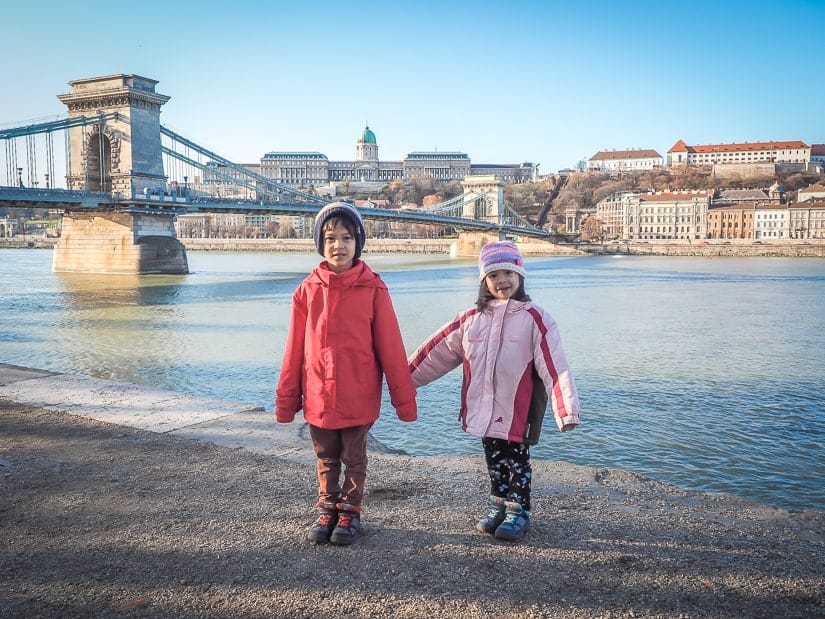 Our kids beside the Danube river in Budapest, with Széchenyi Chain Bridge and Buda Castle in the background