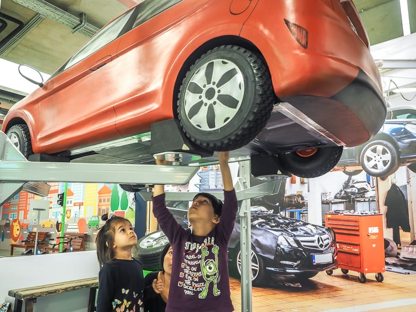 Our kids pretending to repair under a car at MiniPolisz, Budapest