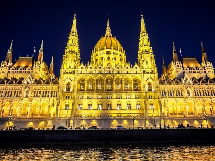 Budapest Parliament Building lit up at night, viewed from a sunset river cruise