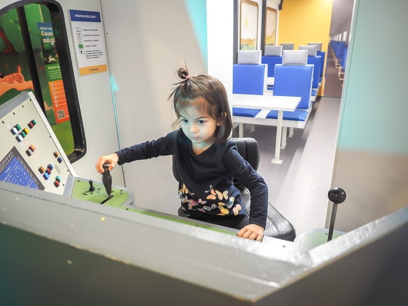 My daughter driving a pretend metro at Minipolisz Budapest