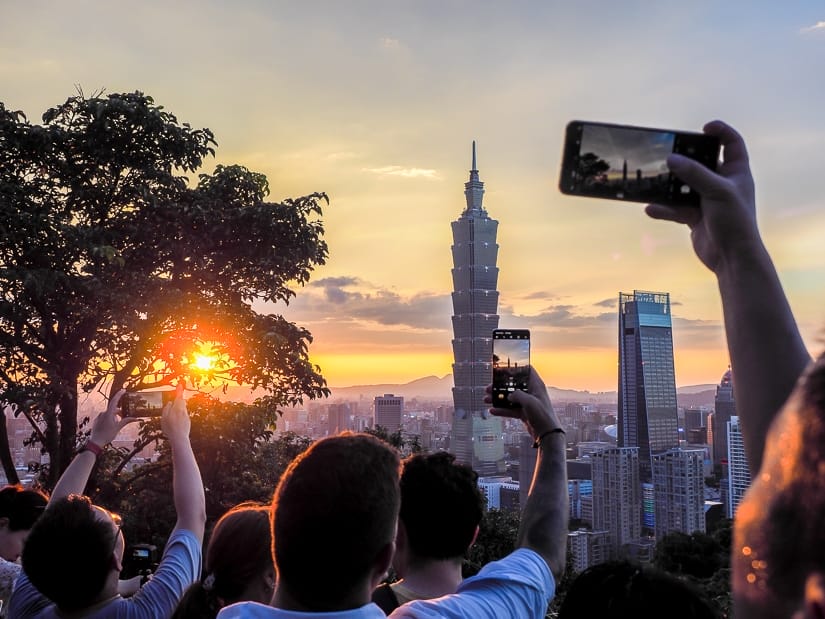 Tourists photographing Taipei 101 from Elephant Mountain in Taipei in summer