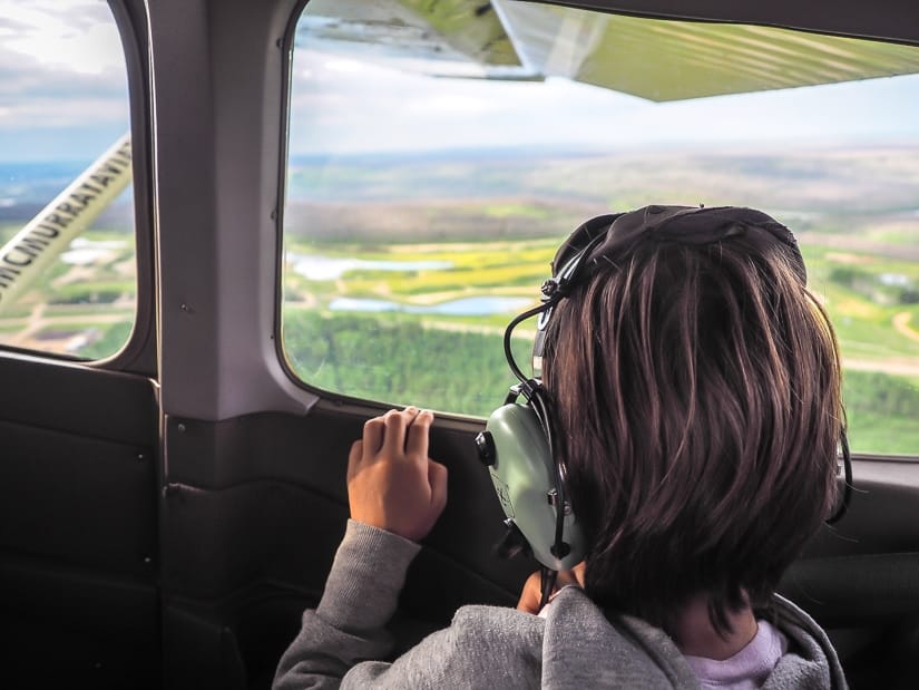 A young girl looking out the window as our aerial tour in Fort McMurray takes off