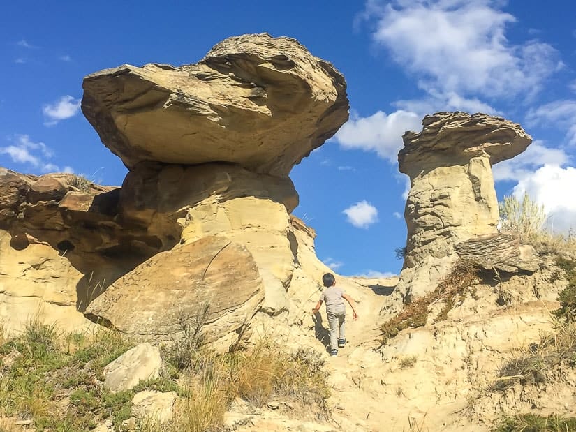 Boy walking between two tall hoodoos on the Badlands Trail