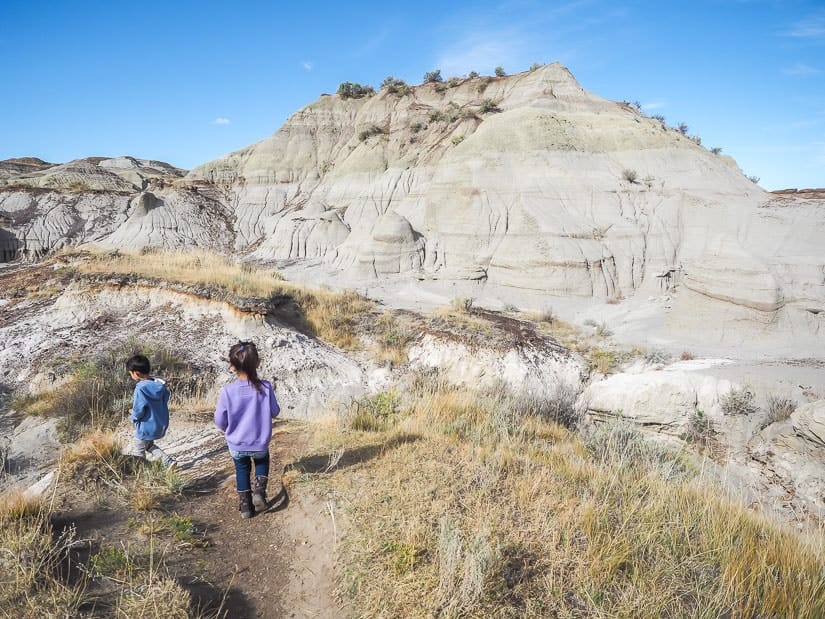 Badlands scenery and two kids walking on the Trail of the Fossil Hunters, Dinosaur Park