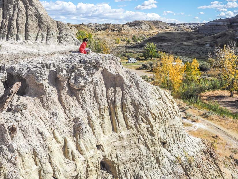 Child on top of a cliff on Coulee Viewpoint Trail, Dinosaur Park hiking