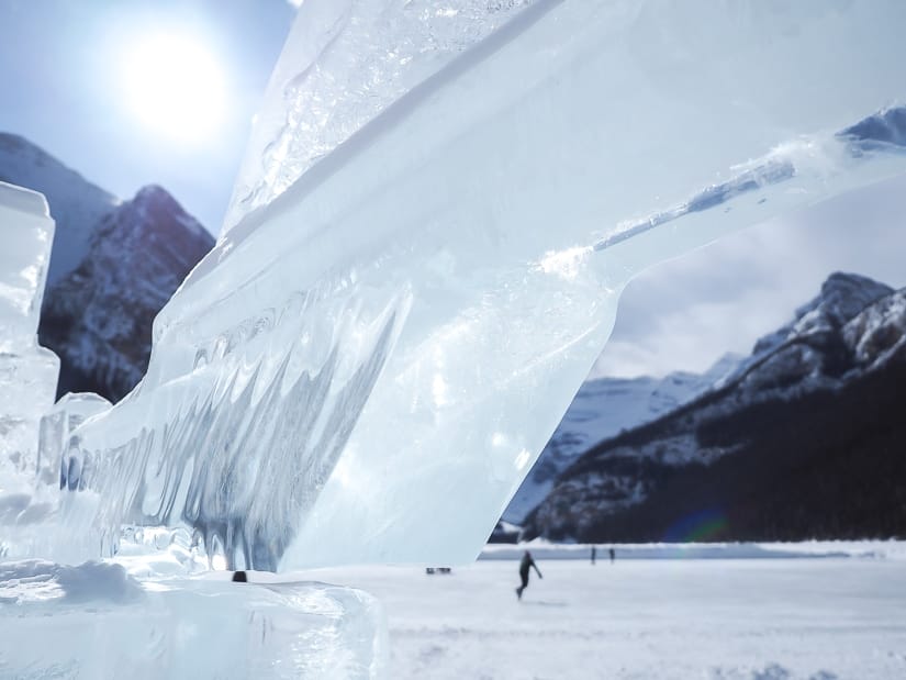 Ice sculpture at Ice Magic Festival in Lake Louise, Banff in winter, with peopel skating on Lake Louise in background