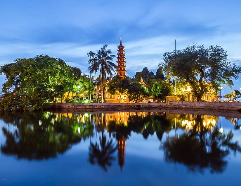 View of Tran Quoc Pagoda reflecting in the lake in the early evening, Hanoi, Vietnam