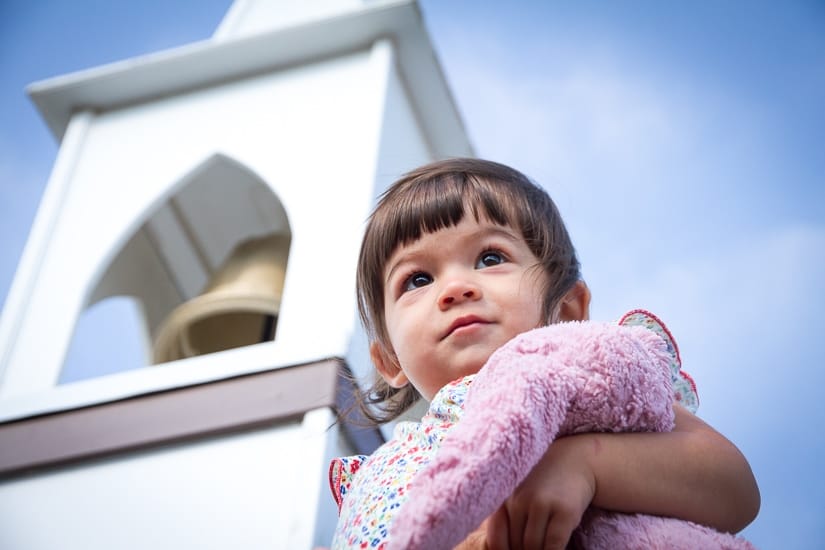 A toddler with the Little Church behind her in Drumheller Alberta