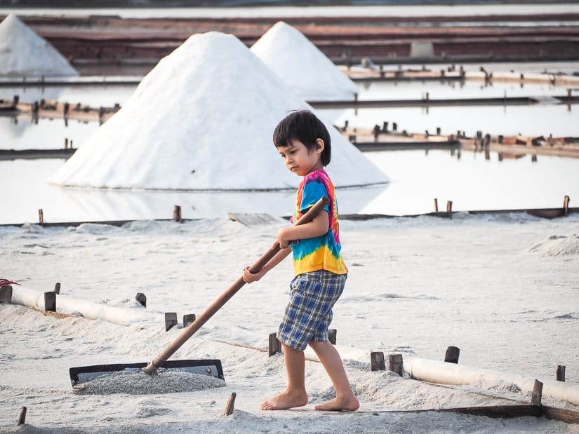 A boy raking salt in a traditional salt field in Taiwan