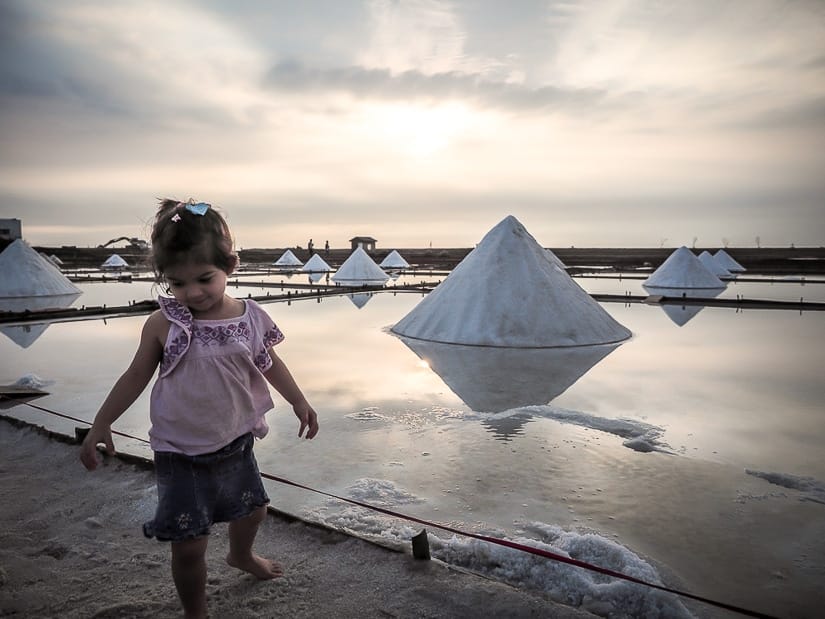 Young girl standing beside salt field