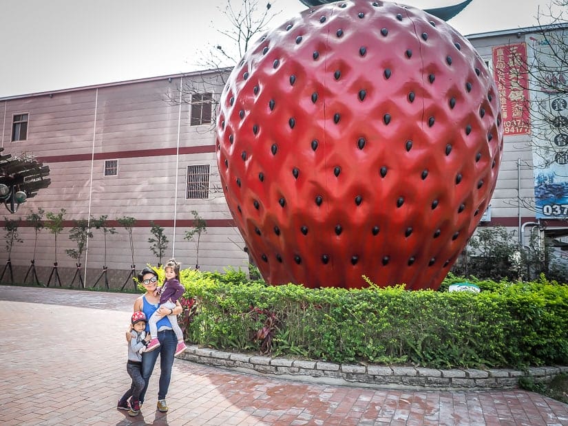 Mother and two kids in front of large strawberry statue at Dahu Wineland Resort Miaoli
