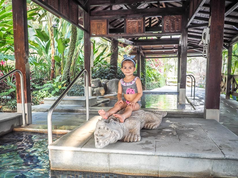 A yong girl sitting on a statue by a hot spring pool in Taian Taiwan