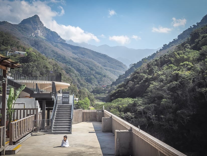 Child on the roof of a hot spring hotel in Tai'an with mountains in the background