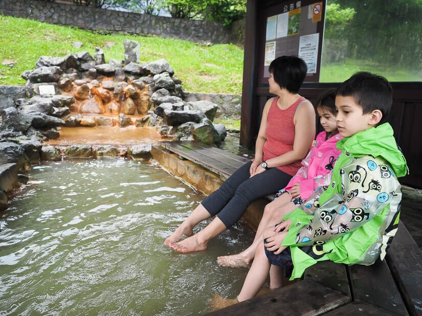 A mother and two kids soaking their feet in a Taiwanese hot spring