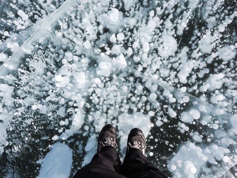 Two feet standing on a whole bunch of frozen ice bubbles at Abraham Lake in Nordegg, Alberta