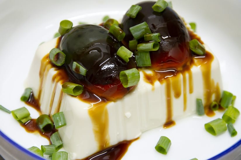 100-year eggs on a block of cold tofu, also called 1000-year eggs and century eggs