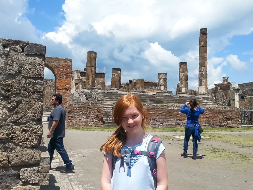 A child posing in front of the ruins of Pompeii in Italy