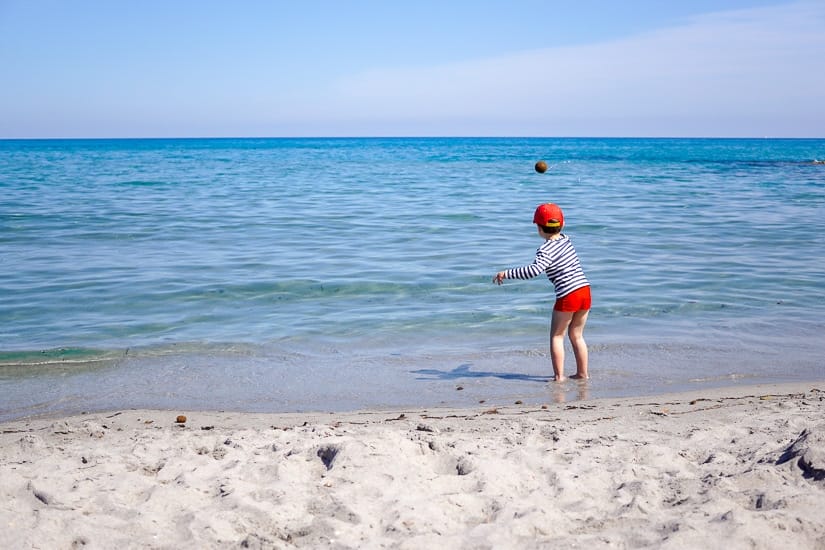 A kid playing on the beach in Sardinia