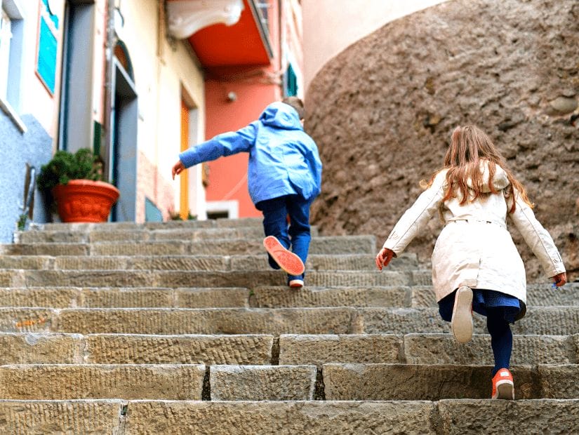 Some kids runnign up a staircase in Cinque Terre