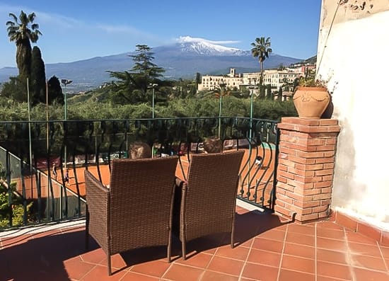 Two kids on a balcony overlooking a volcano in Sicily