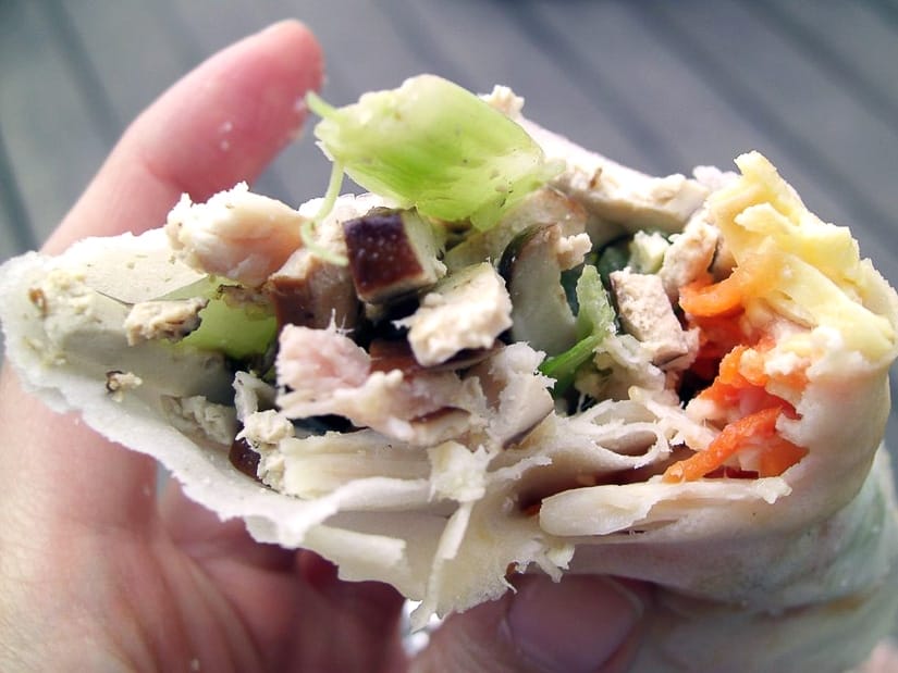 A hand holding a Taiwanese burrito wrap, also called Run Bing