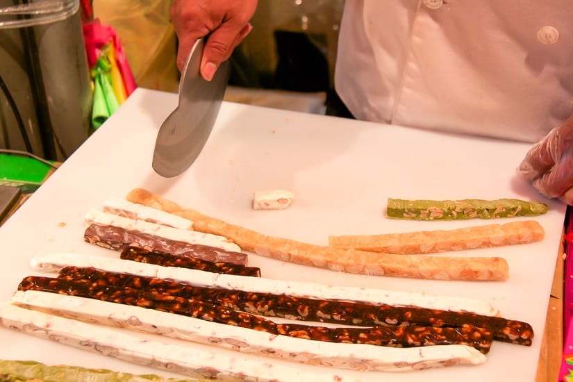 A chef cutting nougat a street food stall