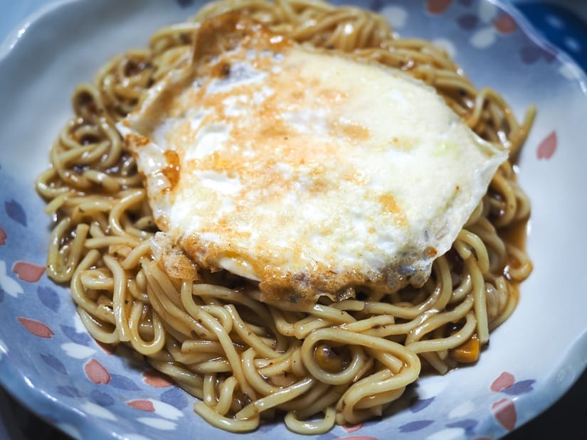 A plate of noodles with fried egg on top