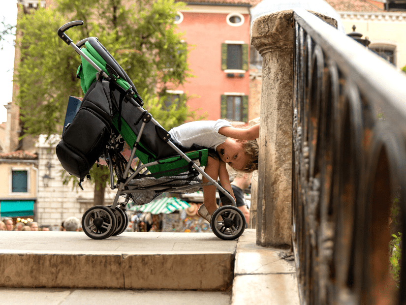 A kid in a stroller on a bridge in Venice, Italy