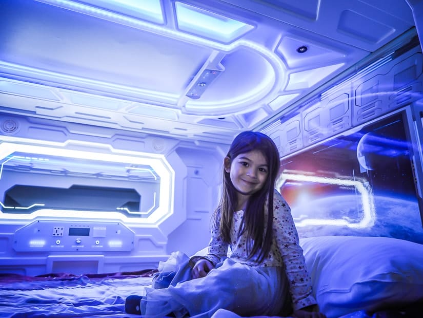 My daughter in her space bed in our themed room at Fantasyland Hotel