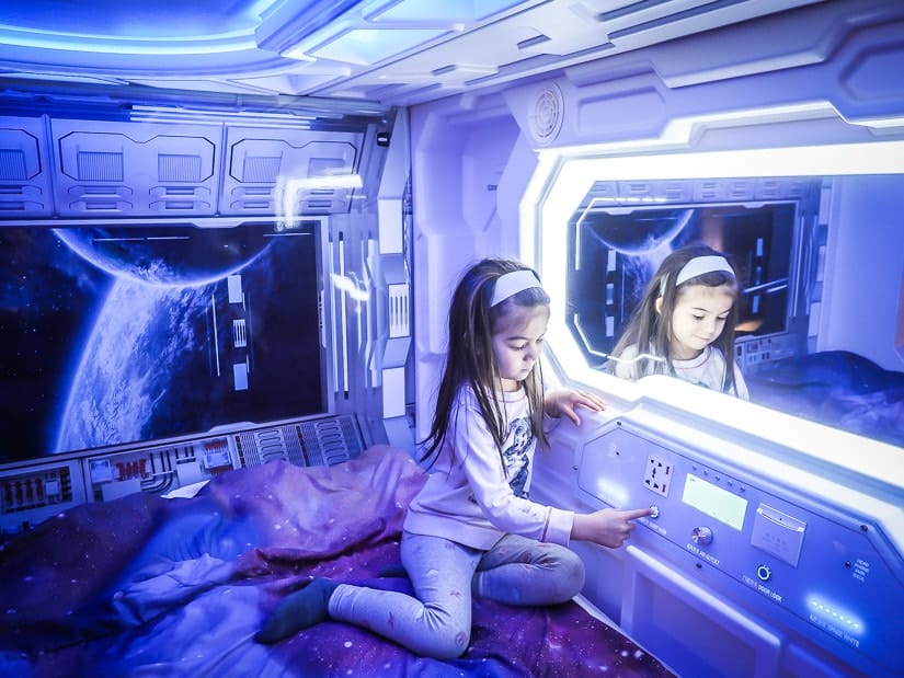 A girl inside a space pod-themed bed in Fantasyland Hotel, West Edmonton Mall