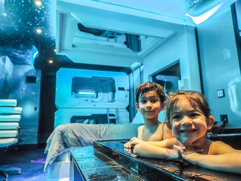 Two kids in a hot tub in a space-themed hotel room in Fantasyland Hotel, the best place to stay with kids in Edmonton