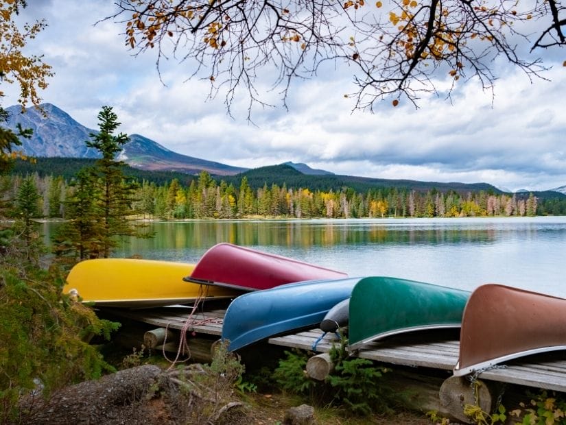 Some canoes lined up beside Beauvert Lake on a cloudy day